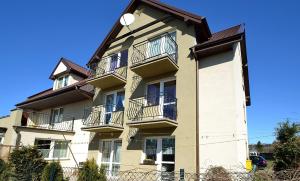 a tall building with balconies and a clock on it at Dom Wczasowy MONIKA in Jastarnia