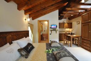 a bedroom with a large bed and a kitchen at Gresil Residence in Champoluc