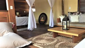 a living room with a bed and a table with a candle at Pousada Jeri Dunas in Jericoacoara