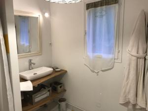 a white bathroom with a sink and a mirror at La Nicoulette in Gapennes