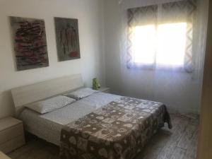 a bedroom with a bed and a window at Casa Pineta in Lido di Jesolo