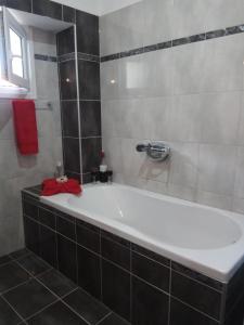 a white tub in a bathroom with a red towel at The Place to be in Kallirákhi