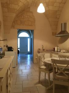 a kitchen with an archway and a table and chairs at La Suite di Martina in Lecce