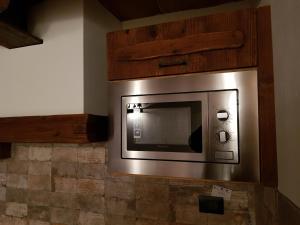 a microwave mounted on a wall in a room at La mansarda delle marmotte in Pré-Saint-Didier