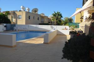 a swimming pool in front of a house at Sirena Kings in Paphos