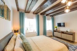 a bedroom with a bed and a tv and windows at Uptown Studio Brasov in Braşov