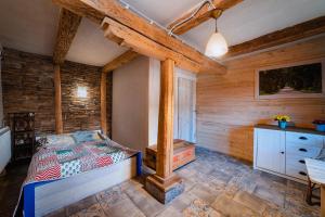1 dormitorio con 1 cama y pared de madera en Folwark Malinowy Chruśniak, en Bisztynek