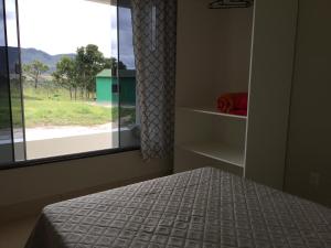 a bedroom with a bed and a window with a view at Mirante do Morro in Alto Paraíso de Goiás