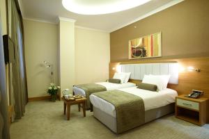 Habitación de hotel con 2 camas y mesa en dovsOtel, en Manisa