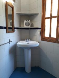 ein Badezimmer mit einem weißen Waschbecken und einem Spiegel in der Unterkunft Casa Chica in Cazorla + 13 Fotos