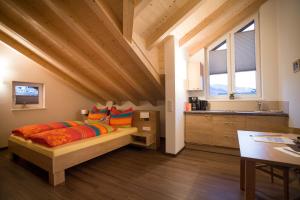 Un dormitorio con una cama con almohadas de colores y un escritorio. en ff Appartements, en Bramberg am Wildkogel