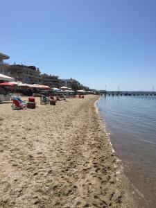 a beach with chairs and umbrellas and the ocean at Cosy apartment in Perea
