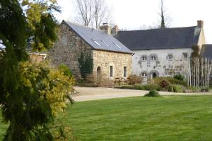un grande edificio in pietra con un prato di Gites de la Haie a Plouégat-Moysan