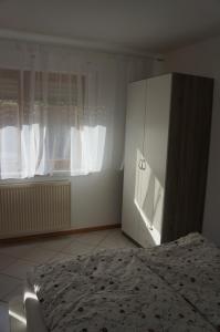 バート・クロツィンゲンにあるFritzのベッドルーム1室(ベッド1台、白いキャビネット付)