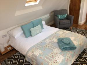 um quarto com uma cama com uma cadeira e uma almofada em Pump View em Weymouth