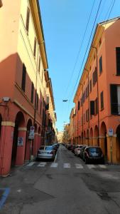 an empty street with cars parked next to buildings at Arpa Apartments Bologna Center in Bologna