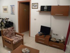 a living room with a chair and a tv on a table at Apartment Soleal Orikum in Orikum
