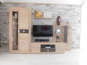 un centro de entretenimiento de madera con TV de pantalla plana en L'Ocell Blau, en Miami Platja