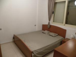 1 dormitorio pequeño con 1 cama y 2 ventanas en Apartment Soleal Orikum, en Orikum