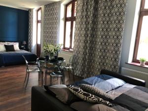 uma sala de estar com um sofá e uma mesa com cadeiras em LivingRoom 1 self Check-in 24h em Katowice