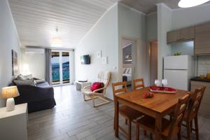 a living room with a dining room table and a kitchen at Captain Nick Aparthotel in Mikros Gialos
