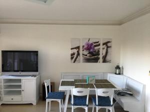 une salle à manger avec une table et une télévision dans l'établissement DElfin Apartmanház, à Balatonfüred