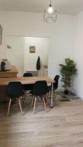 a dining room with a wooden table and chairs at Appartement les Regrattiers in Poitiers