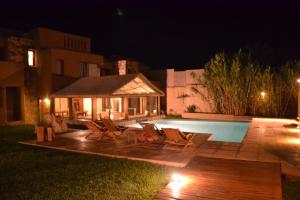a patio with chairs and a swimming pool at night at Vientonorte in Tilcara