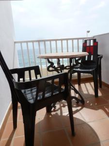 een tafel en stoelen op het balkon bij Hostal Cortés in Garrucha