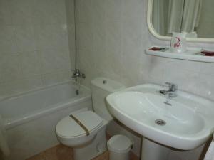 a bathroom with a sink and a toilet and a bath tub at Hostal Cortés in Garrucha