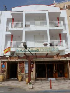 a white building with a bird sitting on a pole at Hostal Cortés in Garrucha