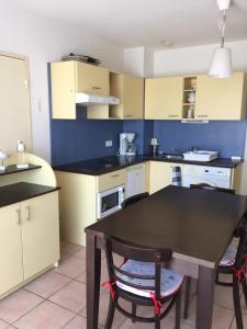 a kitchen with a table and chairs in a room at Appartement dans Les jardins de Phoebus in Gruissan