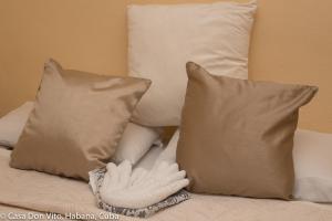 a pair of white gloves sitting on a bed with pillows at Casa Don Vito in Havana