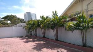 a fence with palm trees in front of a building at Fatimataj Mahal in Miami