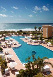 uma vista para uma piscina com cadeiras e para o oceano em Palacio de Sancti Petri, a Gran Meliá Hotel em Chiclana de la Frontera