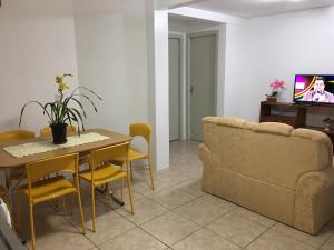 uma sala de estar com uma mesa e um sofá em Confortável Residencia em Carlos Barbosa em Carlos Barbosa