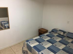 - une chambre avec un lit bleu et blanc et un miroir dans l'établissement Confortável Residencia em Carlos Barbosa, à Carlos Barbosa