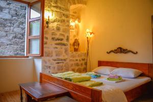 a bedroom with a bed with a table and a window at Old Town Youth Hostel in Kotor