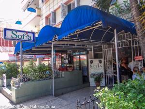 a restaurant with a blue umbrella in front of a building at Casa Don Vito in Havana