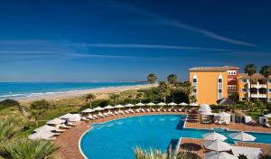 
a beach with a pool and a balcony overlooking the ocean at Gran Meliá Sancti Petri in Chiclana de la Frontera
