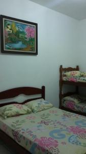 a bedroom with a bed and a picture on the wall at Chácara Recanto dos recantos in Itanhaém
