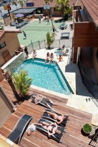 an overhead view of a swimming pool with people laying on chairs at Maxmee Backpackers Resort in Gold Coast