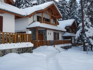 una casa cubierta de nieve con una valla en Saint George Holiday Village, en Borovets