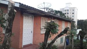 una casa de ladrillo rojo con puerta blanca en Casa para 12 pessoas en Piratuba