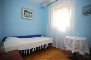 niebieska sypialnia z łóżkiem i oknem w obiekcie Apartment Michelle w Bibinje