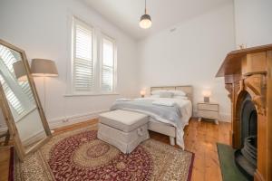 a white bedroom with a bed and a rug at Barossa Valley View Guesthouse in Tanunda