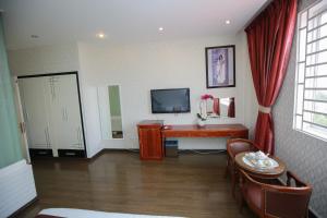 a living room with a television and a table at Lavender Hotel in Thu Dau Mot