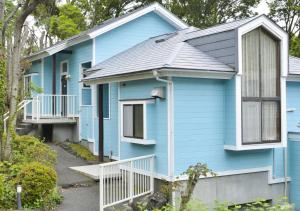 a blue house with a porch and a balcony at Le Nessa Akazawa in Ito