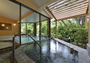 a swimming pool in the middle of a house at Le Nessa Akazawa in Ito