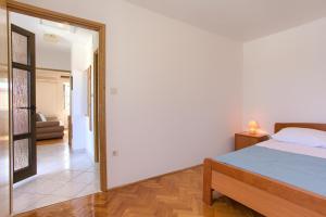 ein Schlafzimmer mit einem Bett und ein Wohnzimmer in der Unterkunft Apartment Iva in Malinska